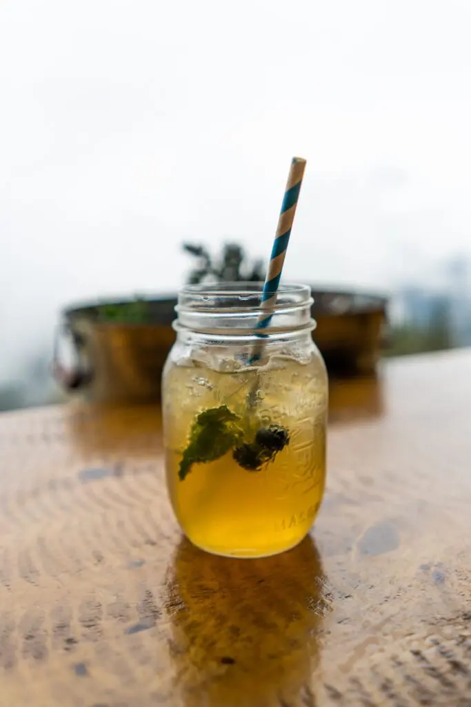 A mason jar mint iced drink at Cliffhouse Bistro, Banff, with a striped straw.