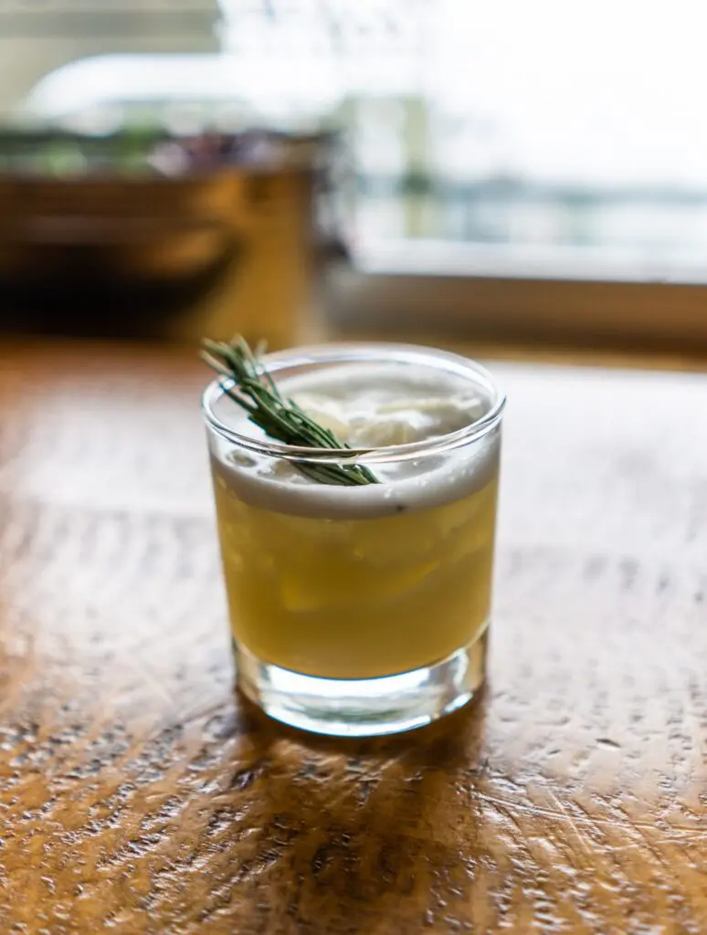 Coconut Abbot Pass Sour cocktail with rosemary garnish at Cliffhouse Bistro, Banff.