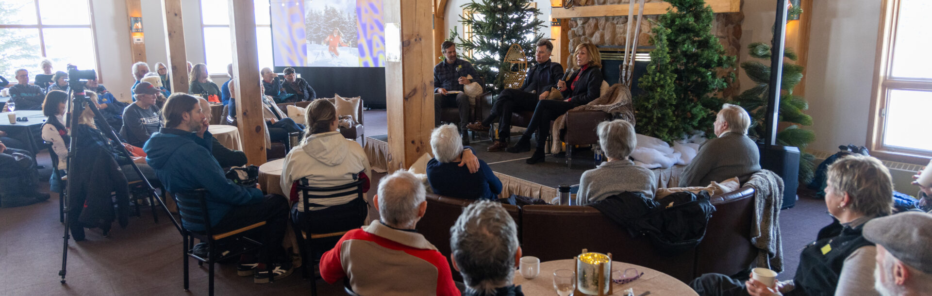 Guests attend a Norquay history fireside chat in a festive, rustic barn venue.